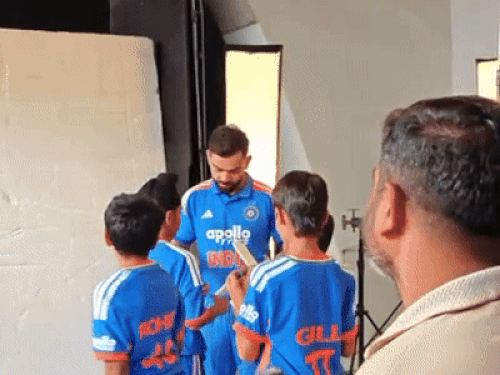 गर्वित के बैट पर ऑटोग्राफ देते विराट कोहली।